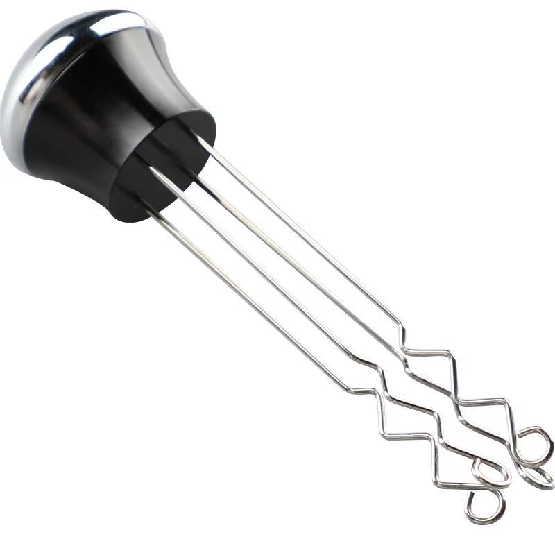 Agitador de café espresso de acero inoxidable en uso, distribuyendo el café uniformemente en el filtro para una extracción perfecta.
