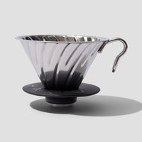 Resistente y Elegante: Diseñada para durar, nuestra V60 Metal Dripper 02 está hecha de acero inoxidable resistente y cuenta con una base de silicona desmontable para facilitar la limpieza. Su diseño atractivo la convierte en una pieza llamativa en cualquier cocina.