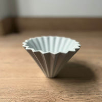 Explora la perfección del café filtrado con el V60 Origami. Diseñado para aquellos que buscan la máxima precisión y un toque artístico en su taza. Con su diseño floral y capacidad para 1-4 tazas, es la herramienta perfecta para apreciar la riqueza de cada grano.